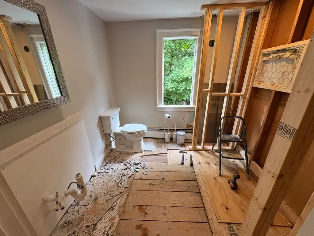 Bathroom renovation with exposed wood framing, partially installed drywall, and toilet visible. by Boston Strong Plastering i