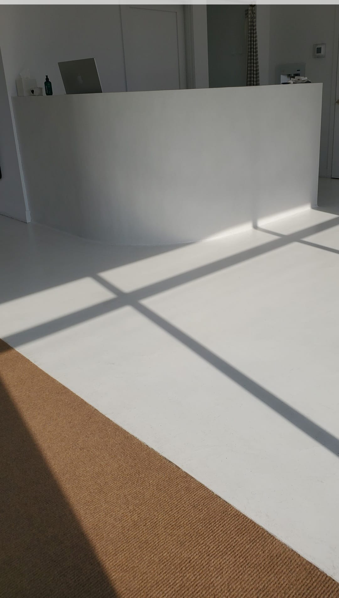 Seamless white microcement floor and curved wall by Boston Strong Plastering, North Shore MA