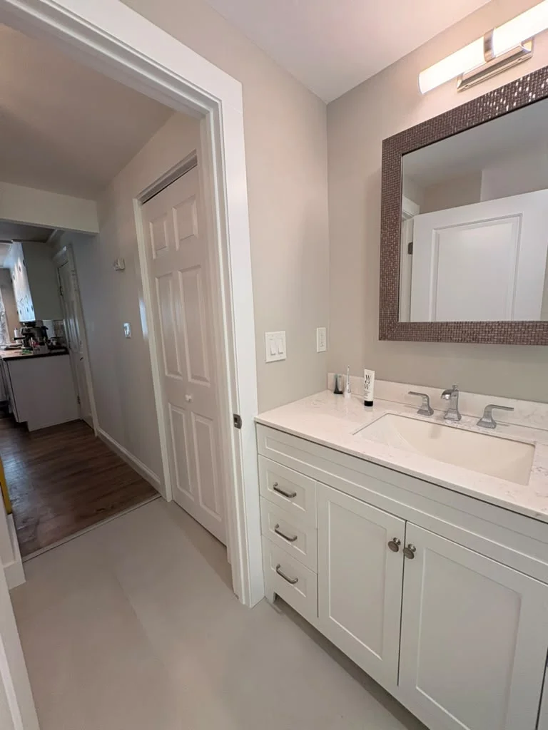 Freshly painted light beige walls in a bathroom and hallway with white trim. by Boston Strong Plastering in Marblehead, MA