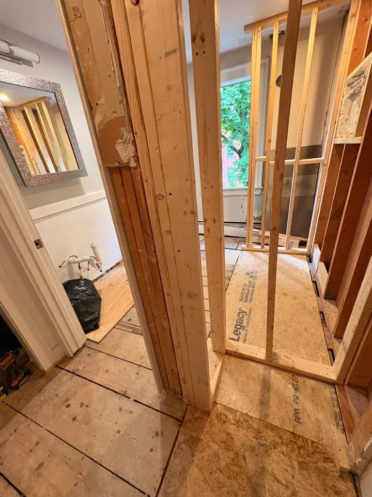 Demolition of old plaster walls revealing wooden lath and new framing for renovation. by Boston Strong Plastering in Manchest